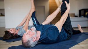 Man and Woman completing stretching exercises at home